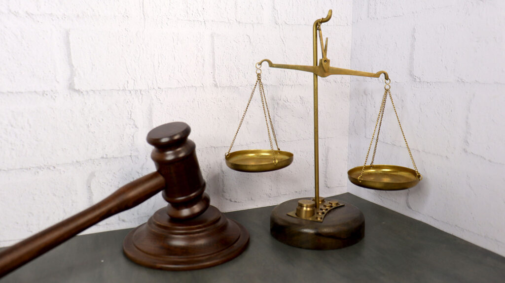 Юридические символы — молоток и весы правосудия на столе
