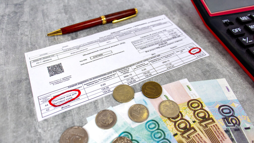 Квитанция за газ и деньги на оплату с акцентом на сумму начислений
