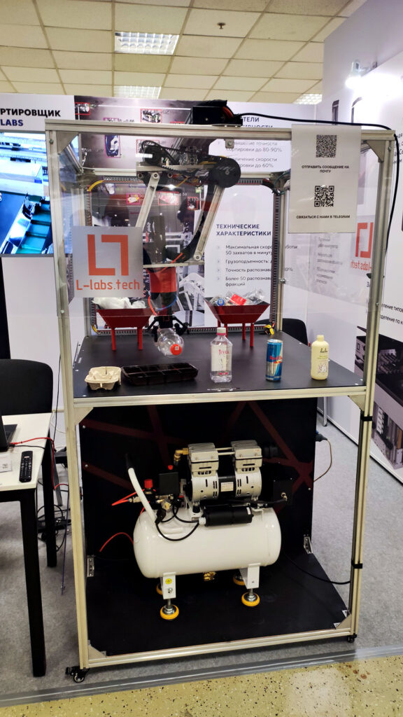 Робот L-Labs с ёмкостью и пластиковыми бутылками на стенде