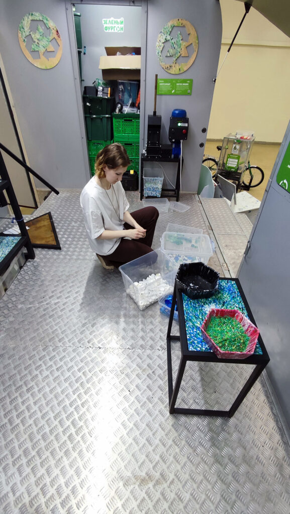 Девушка сортирует пластиковые крышки для переработки