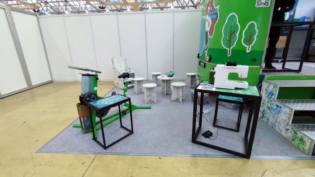 Велостанок, швейная машина и мебель из пластика возле мобильной мастерской